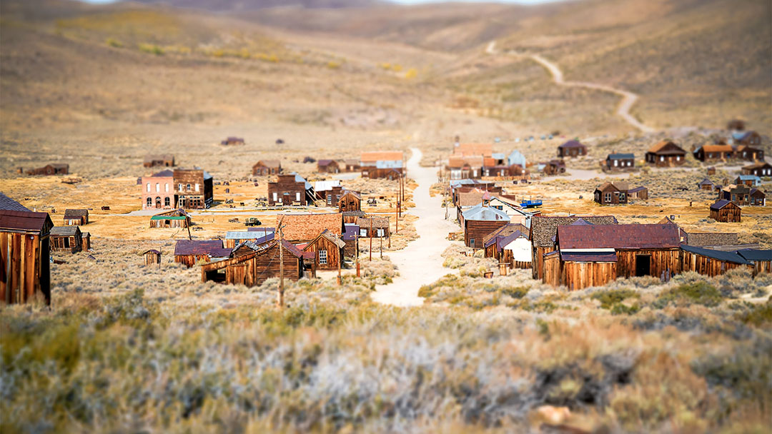 Abandoned desert ghost town with wooden buildings and road