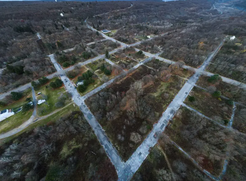 Aerial view of empty roads through wooded abandoned town