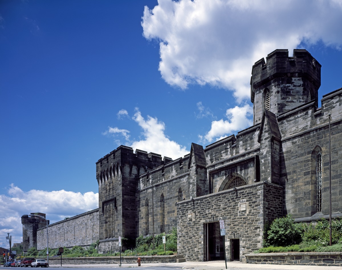 Massive stone prison fortress under bright blue sky
