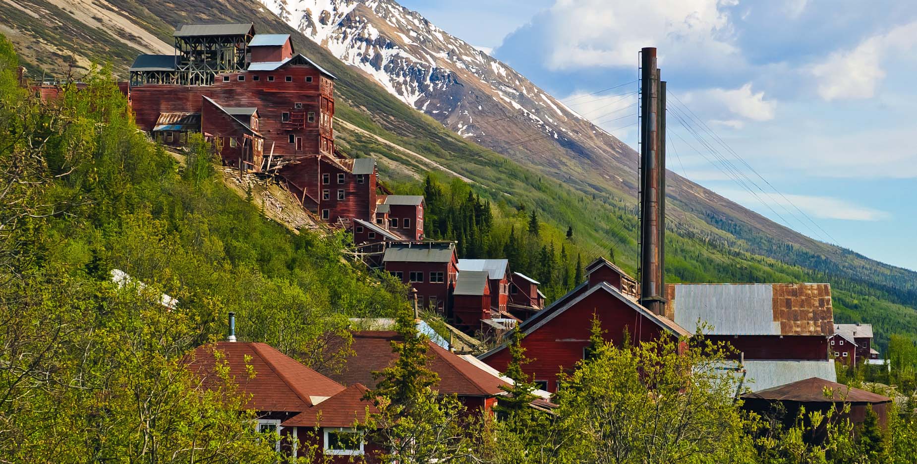 Abandoned mountain mining town with red buildings