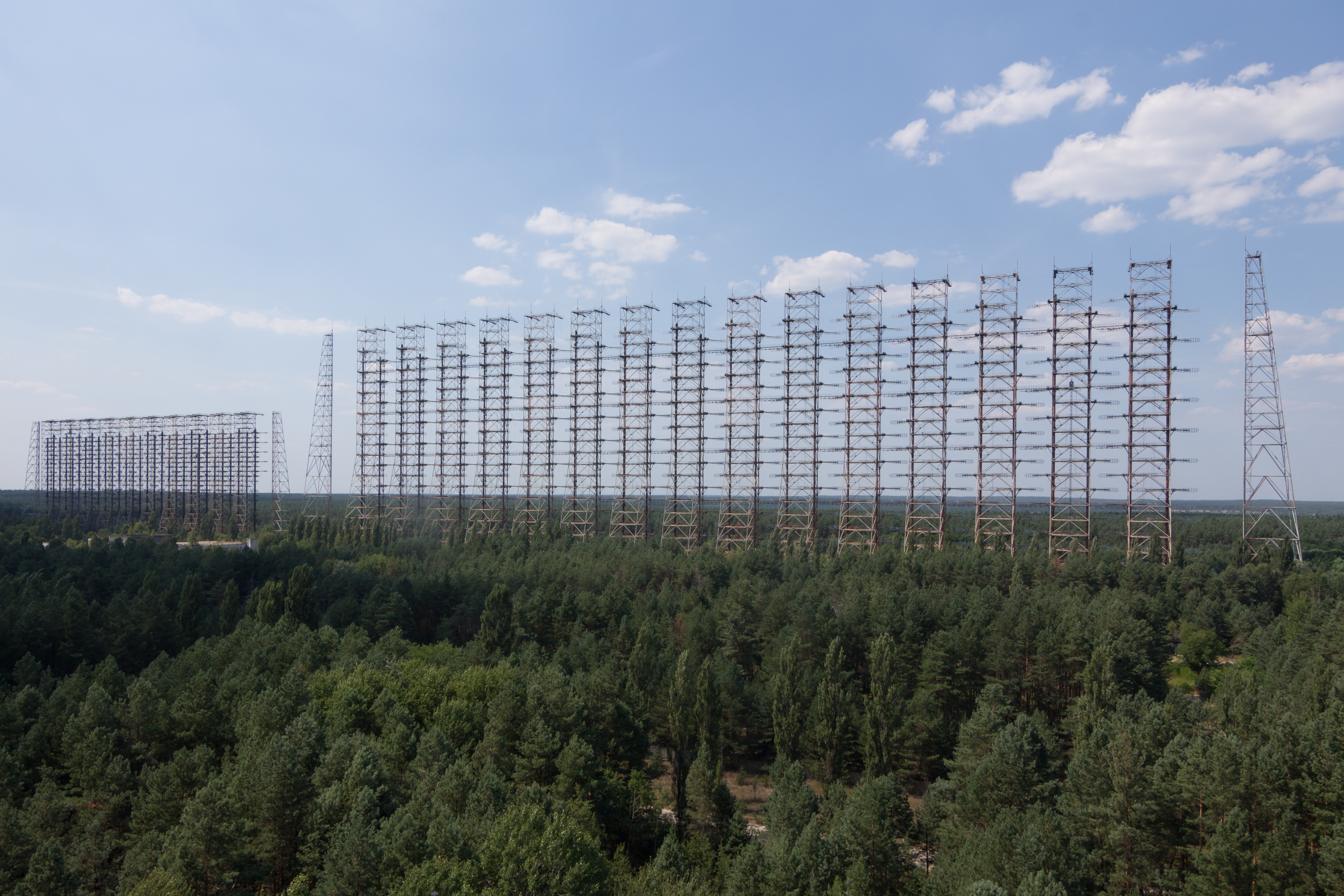 Massive radar array towers above dense green forest