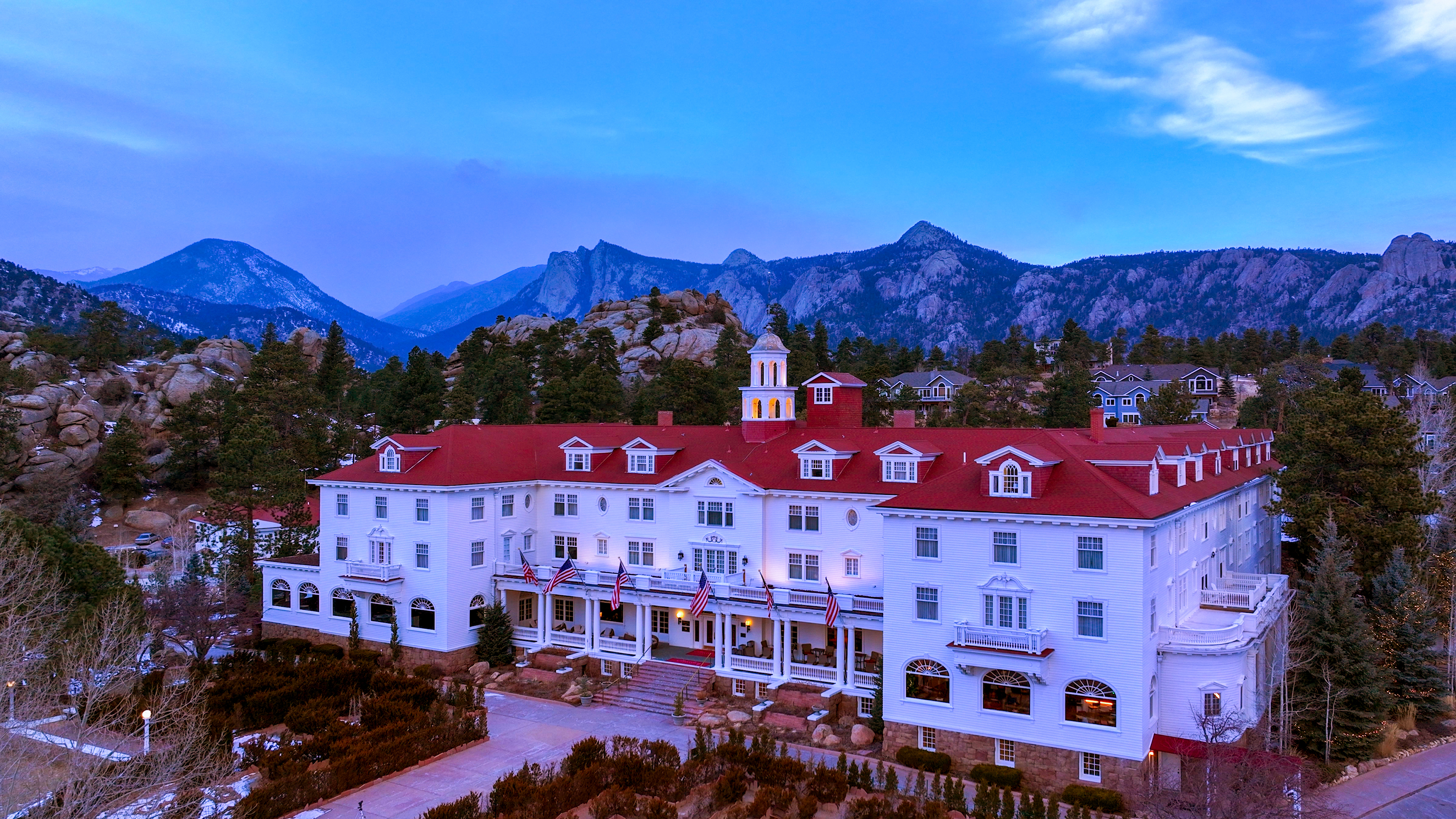 Grand mountain lodge with red roof at dusk