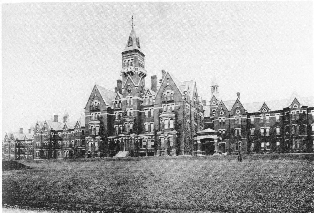Historic asylum complex with central tower in old photo
