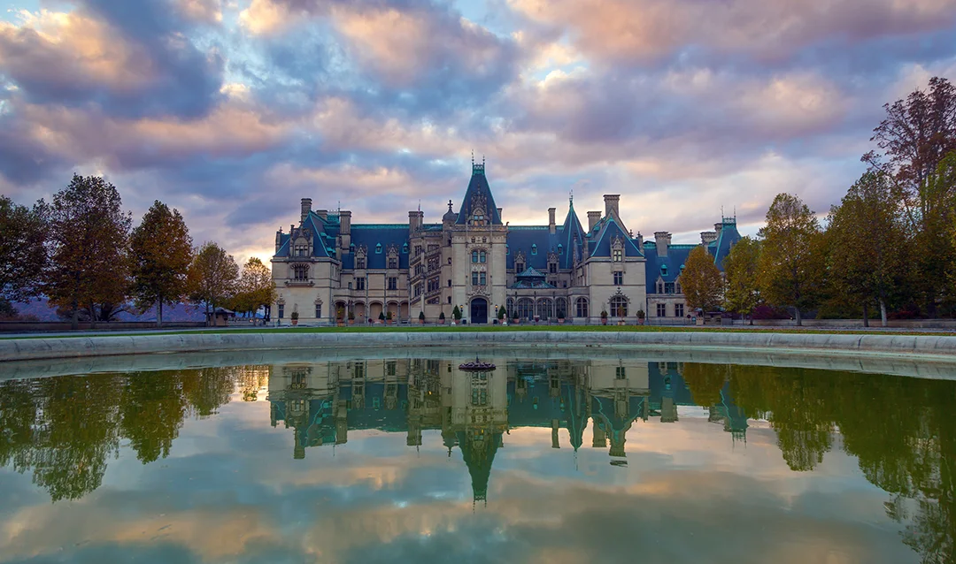 Grand estate mansion reflected in pool at sunset