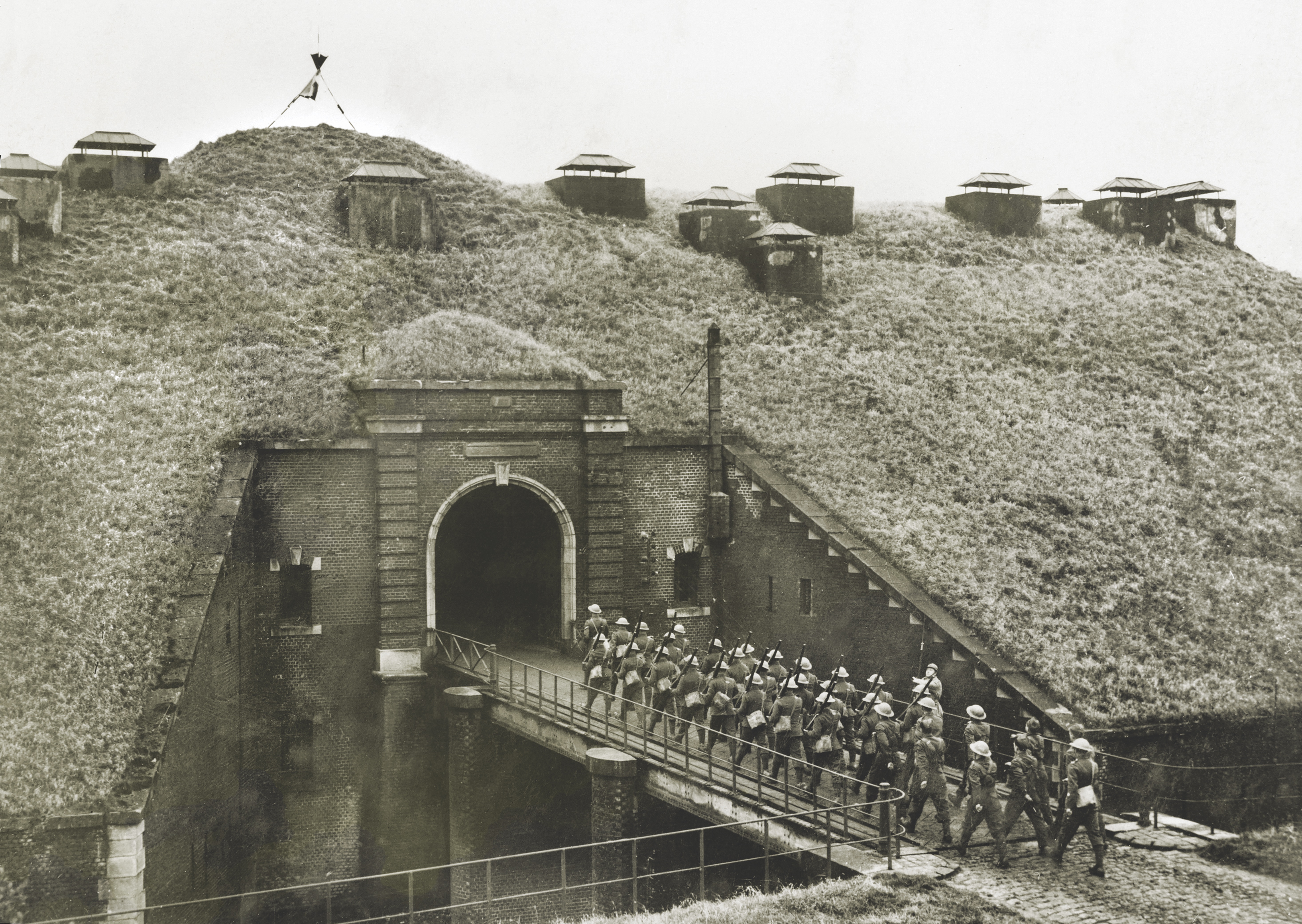 Soldiers march into fortified tunnel beneath grassy hill