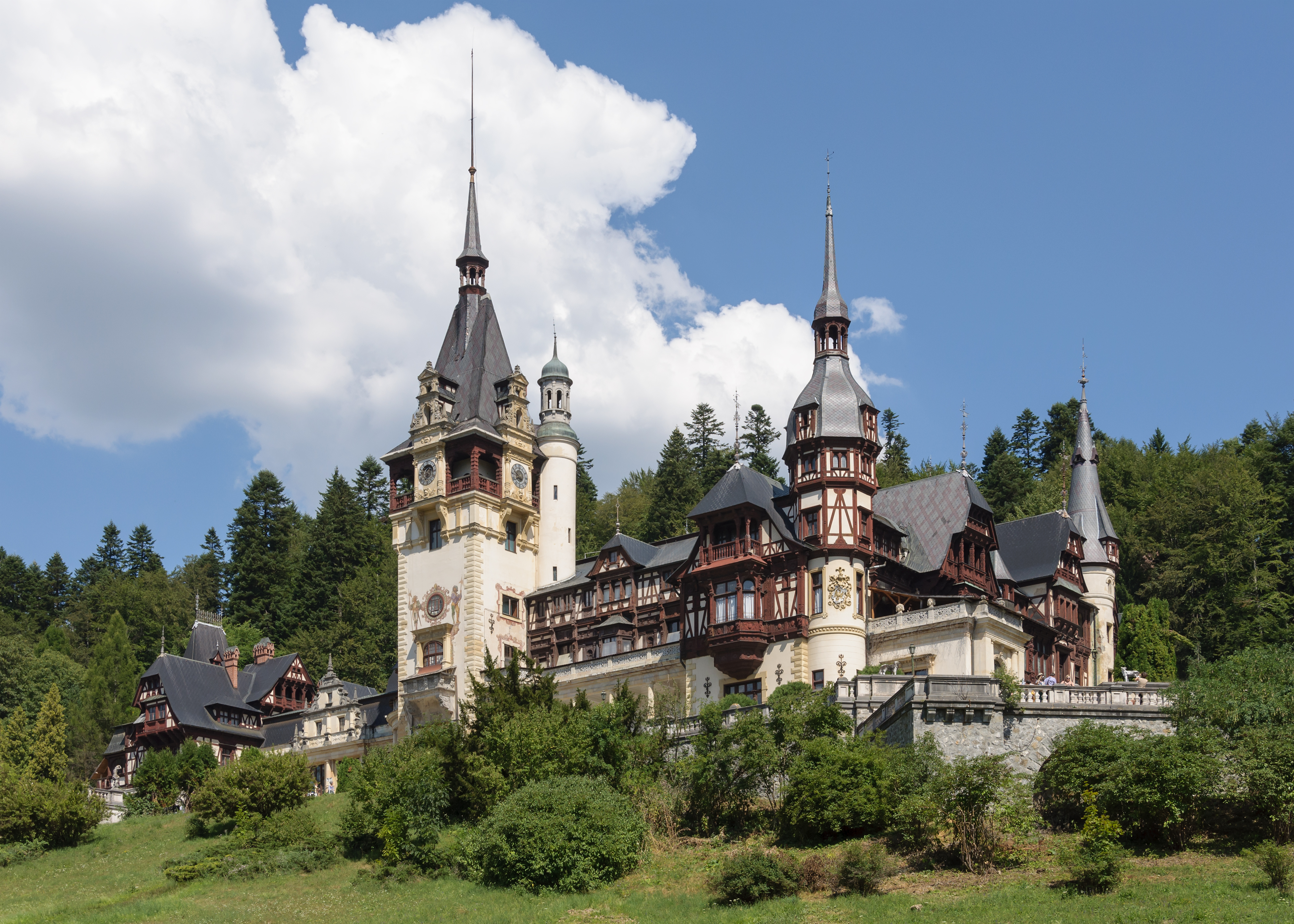 Fairytale castle with tall spires on forested hillside