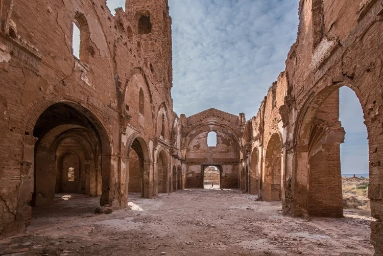 Sunlit ruins of arched brick hall in desert