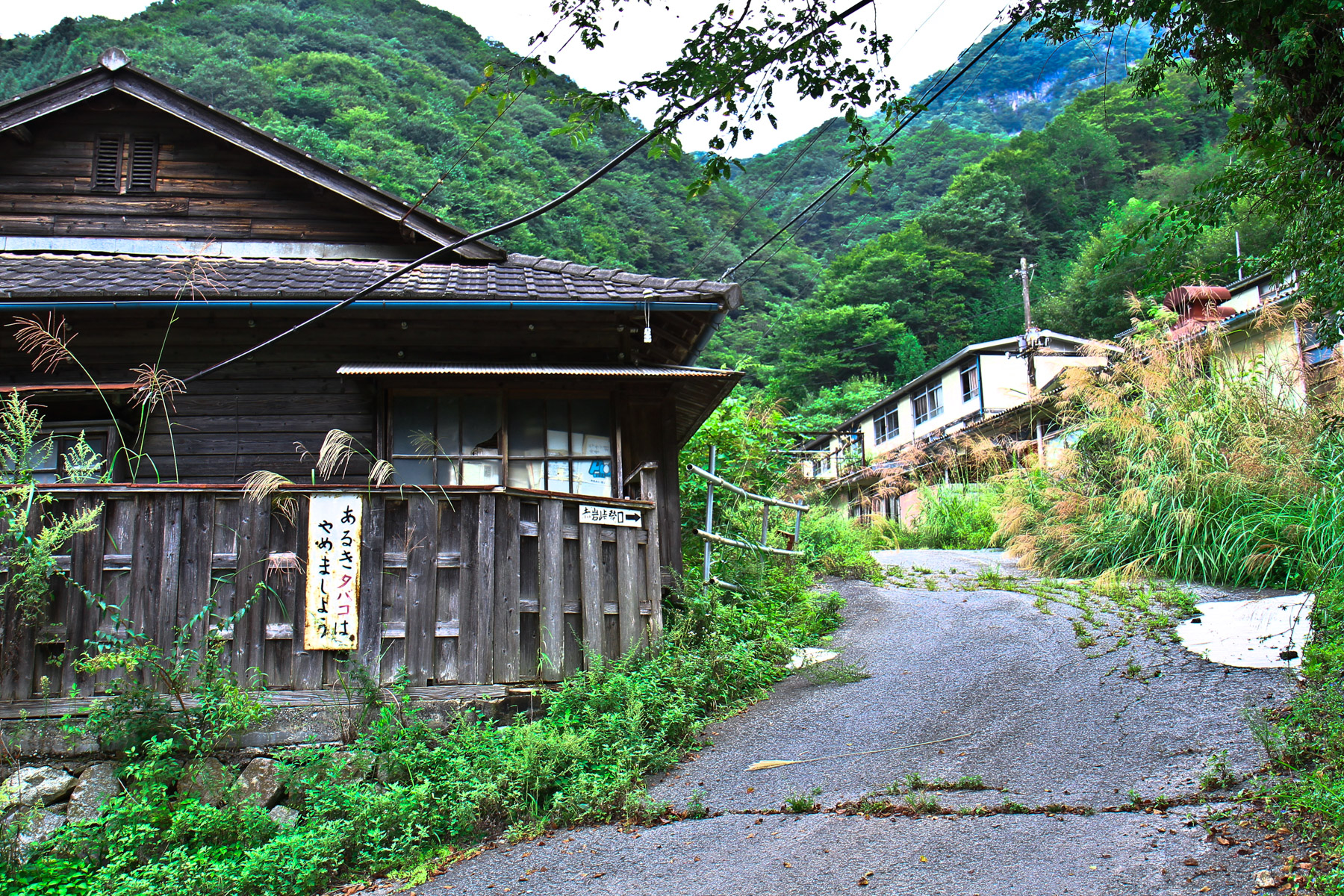 Quiet mountain lane beside weathered Japanese wooden houses